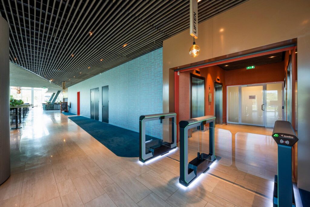 Moderne entreehal met beveiligingspoortjes en liften in een kantoorpand aan de David Ricardostraat.